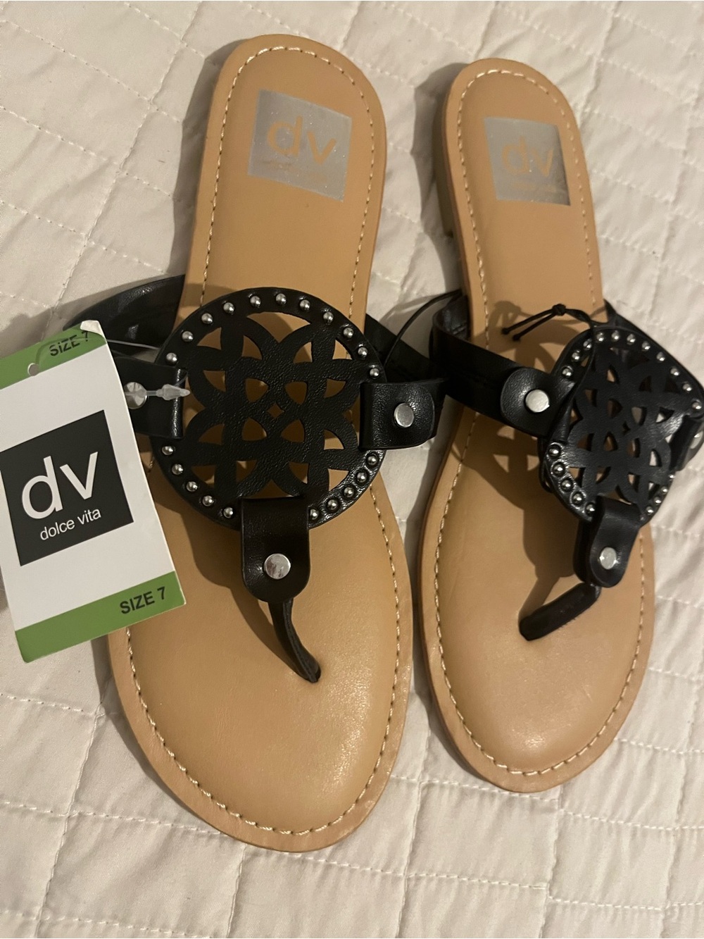 Dolce Vita Gotie thong sandals feature a laser-cut, studded medallion design.